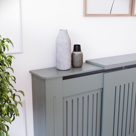 Adjustable Chelsea radiator cover in olive grey with a decorative slatted front.
